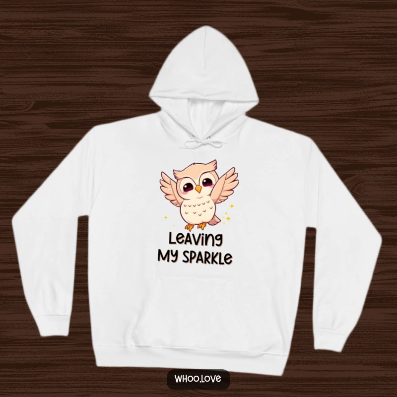 Funny joyful owl hoodie, depicting an owl fluttering its wings with a happy glow and leaving a sparkly trail, offering warmth and magical charm.