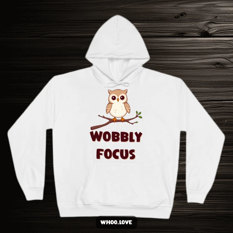 Funny, cozy hoodie featuring a determined small owl character balancing with great effort on a single, wobbly branch.