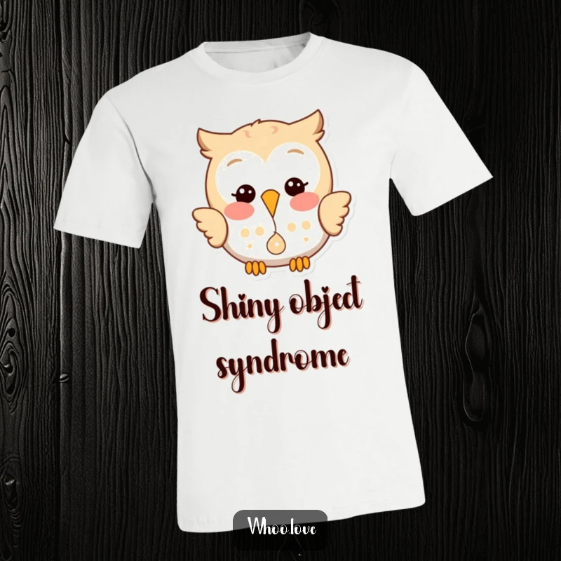 Funny t-shirt depicting a happy owl with a mischievous glint, joyfully dropping a small, shiny object.